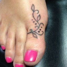 a woman's foot with a flower tattoo on her left toe and pink nail polish