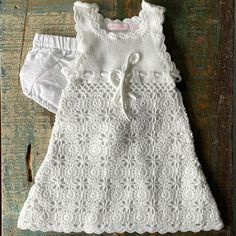 a white dress and diaper on a wooden surface with an old door in the background