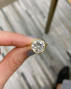 a woman's hand holding an engagement ring