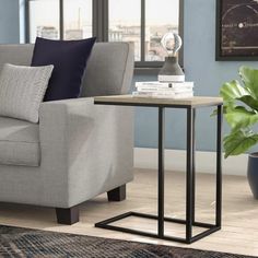 a living room with a couch, chair and end table in front of a window