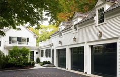 a white house with black garage doors and windows