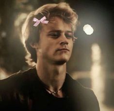 a man with a pink bow in his hair