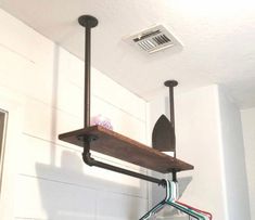 a shelf with some clothes hanging from it's sides and an air conditioner in the background