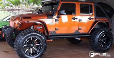 an orange jeep is parked in a garage