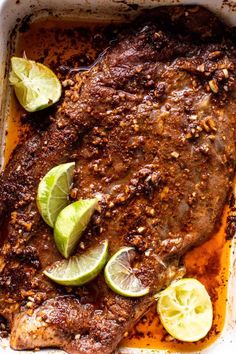 steak with limes and seasoning in a baking dish