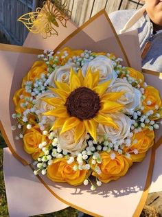 a bouquet of sunflowers and other flowers is being held by someone