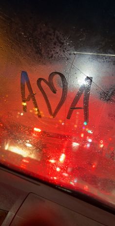 the back window of a bus with graffiti on it's side and red lights behind it