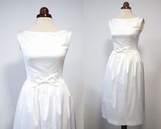 two dresses on mannequins, one in white and the other in ivory