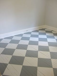 an empty room with checkered floor and white walls