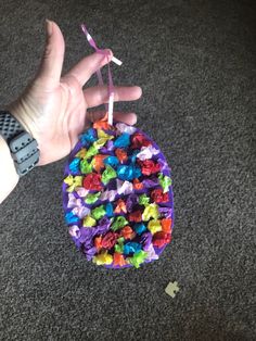 a hand holding a small bag filled with candy