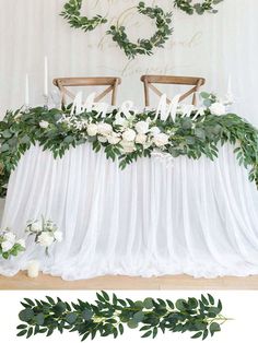 the table is decorated with greenery and white flowers