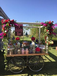 an outdoor bar with flowers, candles and candy on the back wheel is decorated for a baby shower