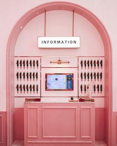 a pink room with an information desk in the center