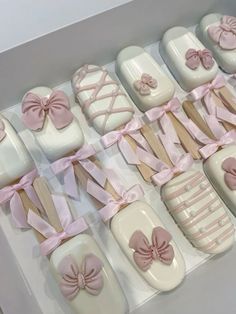 a box filled with white and pink decorated cookies