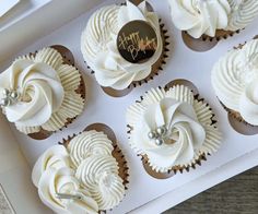 six cupcakes with white frosting in a box