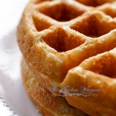 two waffles stacked on top of each other on a white plate with the words, the kitchen whisperers