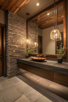 a bathroom with stone walls and lights on the ceiling, along with a large mirror