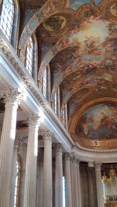 the interior of a church with columns and paintings on the ceiling