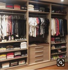 an organized closet with clothes and shoes on the shelves, drawers, and hanging rails