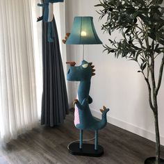 a lamp that is on top of a table next to a plant and a window