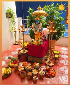 an idol sitting on top of a table filled with fruits and other food items in bowls