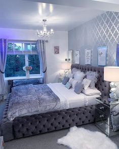 a bedroom with a large bed and chandelier