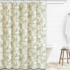 a bathroom with a bathtub, shower curtain and wooden stool in front of it