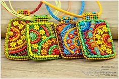 three colorful beaded purses sitting on top of a wooden table next to each other