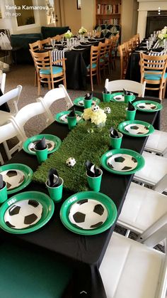 a table set up with soccer themed plates and green napkins on top of it