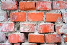 an old brick wall made out of red bricks and cement mortared in to it