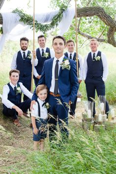 a group of young men standing next to each other in front of a white tent