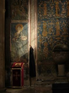 an old church with paintings on the walls and a cross in front of it's alter