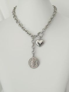 This elegant St. Benedict Medal Lariat Necklace combines style and protection in one piece. Crafted from high-quality stainless steel with a silver finish, this Y-shaped Lariat necklace is a statement of faith and fashion. The St. Benedict medal and steel heart make it a unique and meaningful piece, ideal for everyday wear. Perfect as a Catholic gift for Christmas or an anniversary, this necklace is a beautiful addition to any religious jewelry collection. Its modern and on-trend design makes it suitable for any occasion, whether casual or special. The chunky St. Benedict charm is a powerful symbol of protection and spiritual strength, while the steel heart adds a delicate touch. This necklace is not only a fashion accessory, but also a reflection of devotion, ideal for those looking to co Silver Lariat Stainless Steel Jewelry, Valentine's Day Silver Chain Necklace With Adjustable Chain, Silver Lariat Necklace In Stainless Steel, Silver Stainless Steel Lariat Necklace, Silver Stainless Steel Necklace For Valentine's Day, Adjustable Silver Stainless Steel Chain Necklace, Adjustable Stainless Steel Silver Chain Necklace, Silver Chain Necklace With Lobster Clasp For Valentine's Day, Silver Lariat Chain Necklace Gift