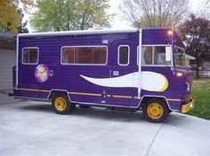 a purple bus parked in front of a garage