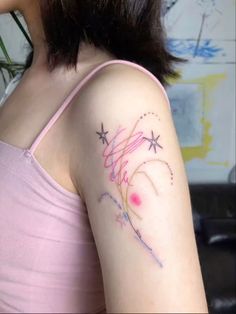 a woman with a tattoo on her arm that has fireworks coming out of the sky