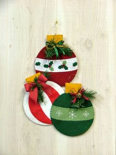 three christmas ornaments hanging on a wooden wall