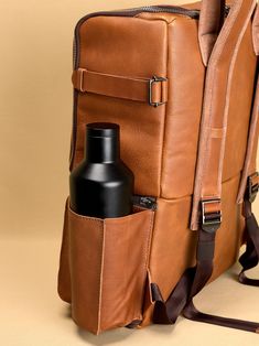 a brown leather backpack with a bottle in it