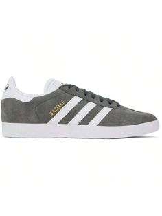 adidas Originals 
Gray & White Gazelle Sneakers 
Low-top nubuck and buffed faux-leather sneakers in gray and white. 
. Lace-up closure 
. Logo embossed at padded tongue 
. Padded collar 
. Signature serrated stripes at sides 
. Logo stamp at outer side 
. Logo bonded at heel tab 
. Padded footbed 
. Mesh lining 
. Textured treaded rubber sole 
Supplier color: Solid grey/White/Gold metallic 
Upper: leather, synthetic. Sole: rubber. 
Made in Viet Nam. 
241751M237065 
Originals Gray & White Gazelle White Gazelle, Casual Athletic Shoes, Logo Stamp, Outdoor Shoes, Leather Sneakers, Outdoor Sports, Gray White, Low Top, White Lace