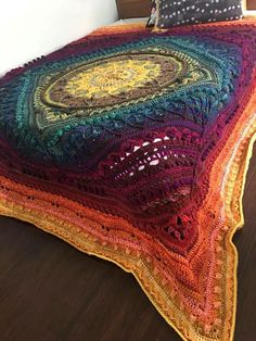 a multicolored crocheted blanket on a bed