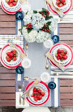 the table is set with strawberries and flowers