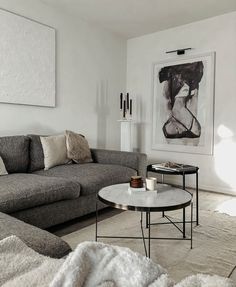 a living room filled with furniture and a painting hanging on the wall above it's coffee table