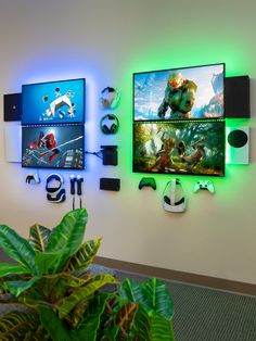 three video game screens mounted to the side of a wall next to a potted plant