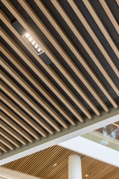 the ceiling is covered with wooden slats and lights are on top of each other