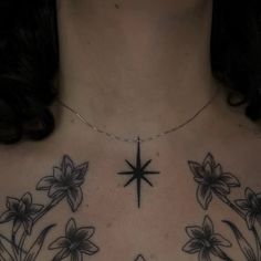 a woman's chest with flowers and a star tattoo on the back of her neck