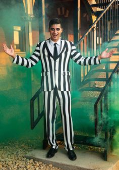 a man dressed in a striped suit and tie posing for the camera with his hands out