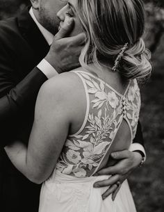 a bride and groom share a tender moment as they stand close to each other in black and white