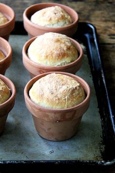 six small bowls filled with bread on top of a baking sheet