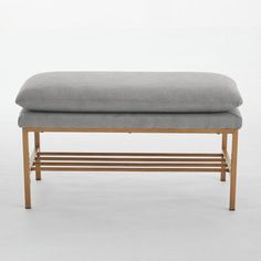 an upholstered bench with wooden legs and a gray fabric seat cushion on it