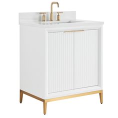 a white bathroom vanity with gold faucet and sink