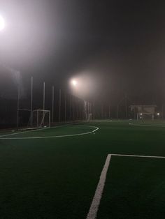 a foggy soccer field at night with lights on